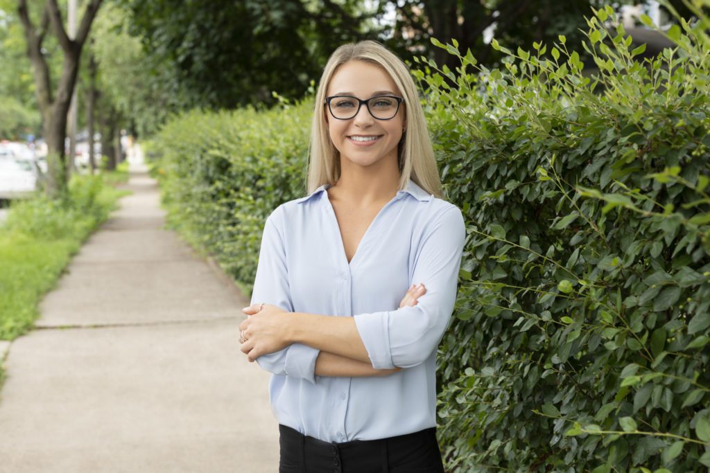 woman smiling near bushes